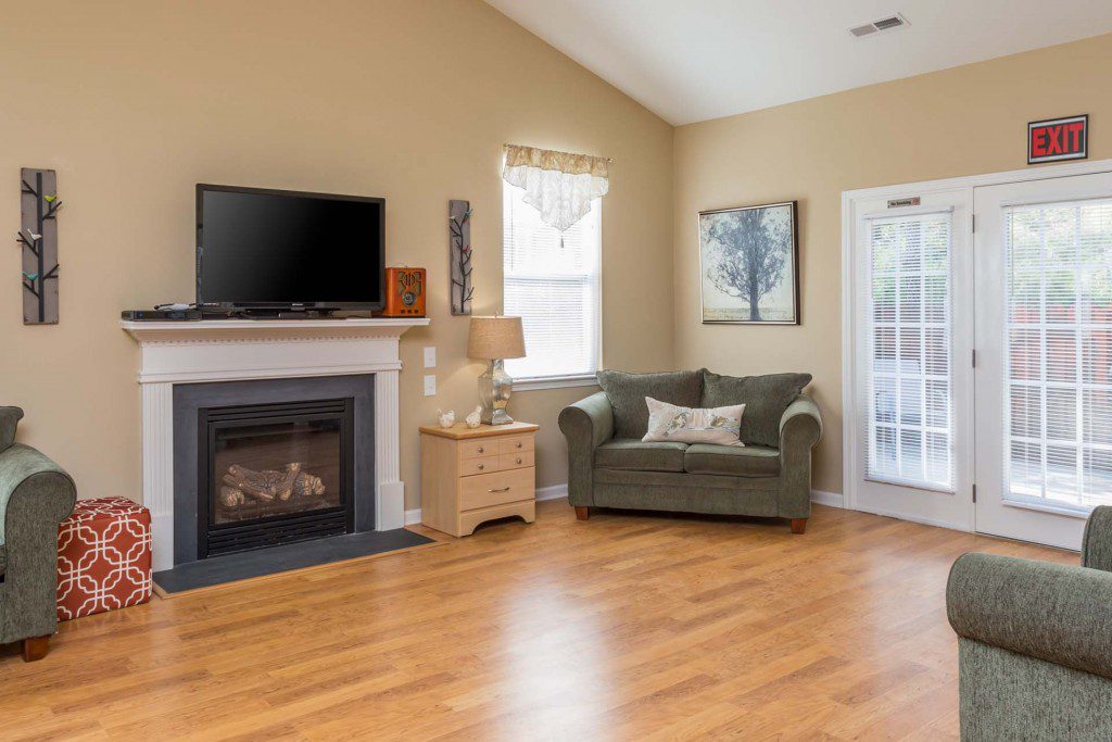 Sunlit living room with a fireplace and patio doors at Avendelle at Lazy River