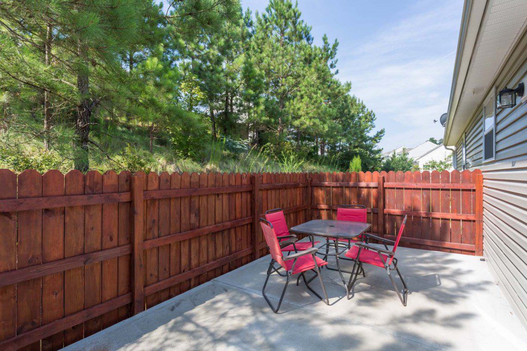 Fenced outdoor patio with a table and chairs at Avendelle at Lazy River